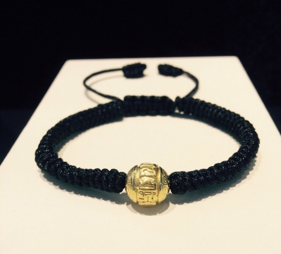 Vòng dây tết đen charm úmani vàng